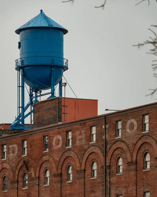 water tower over faded brick lettering